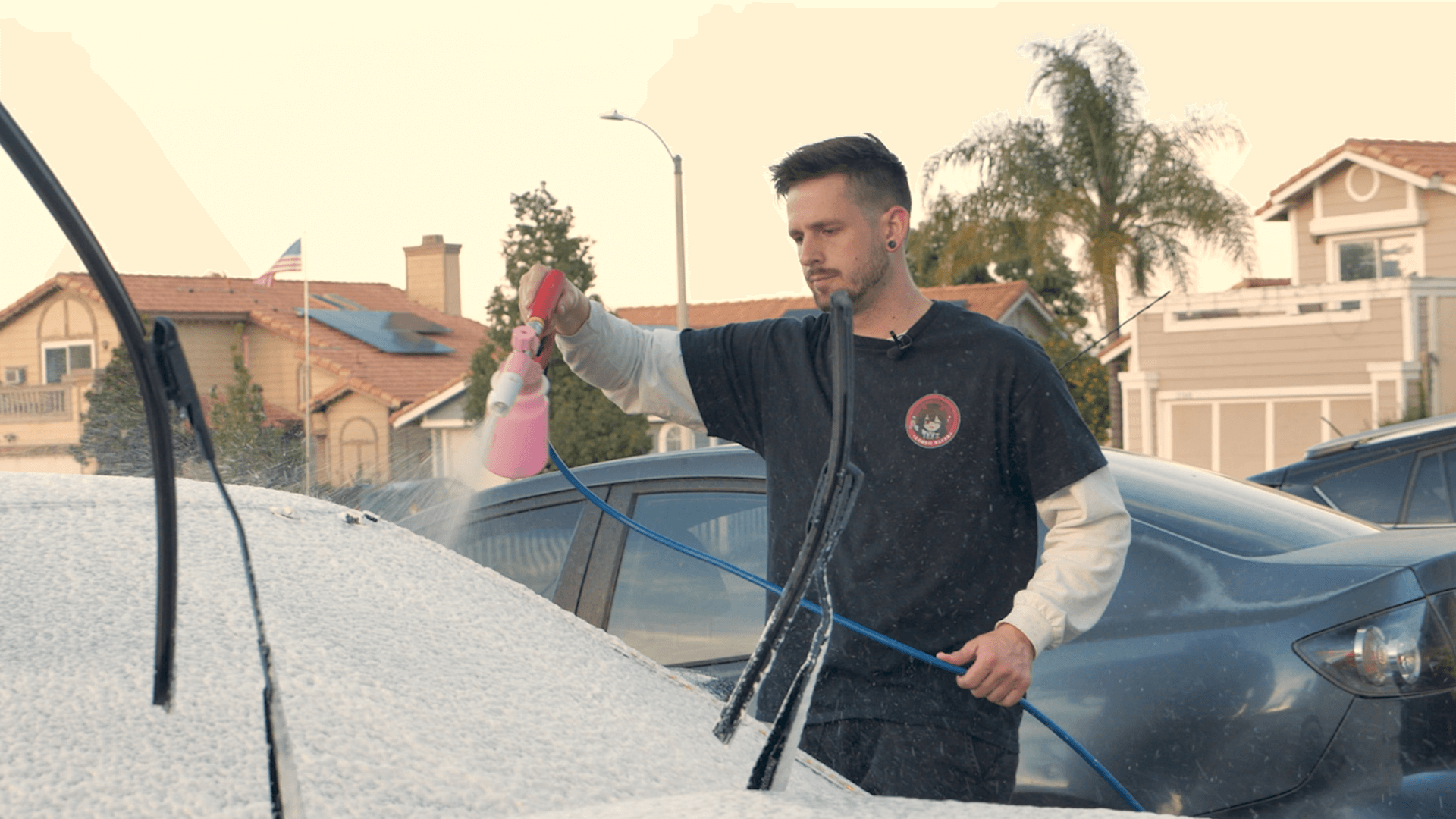 A Man washing a car with a foam cannon.